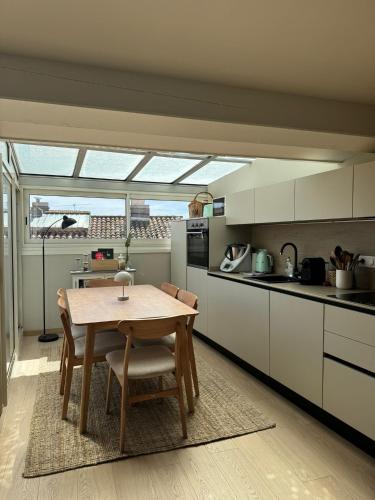 une cuisine avec une table en bois et une salle à manger dans l'établissement Charmant appartement type loft au cœur de Sanary, à Sanary-sur-Mer