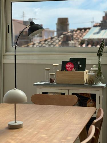 une table avec une lampe devant une fenêtre dans l'établissement Charmant appartement type loft au cœur de Sanary, à Sanary-sur-Mer