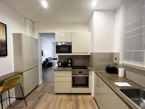 une cuisine avec des armoires blanches et un comptoir dans l'établissement Urban Flat 64 - Luxury flat Mermoz - Champs Elysees, à Paris