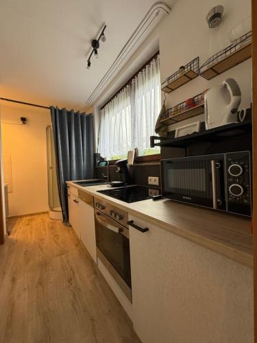 a kitchen with a stove top oven next to a window at Ferienwohnung Christine in Bergneustadt
