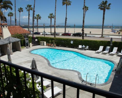 a beach with palm trees and a pool of water at Hotel Milo Santa Barbara in Santa Barbara