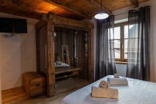 a bedroom with a bed and a tv and a window at Mountain Dolomiti Apartments-Maison Perrod in Predazzo