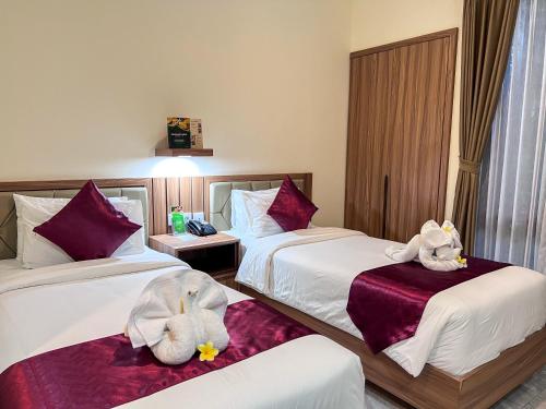 a hotel room with two beds with stuffed animals on them at Casa Verde Guest House in Sempidi