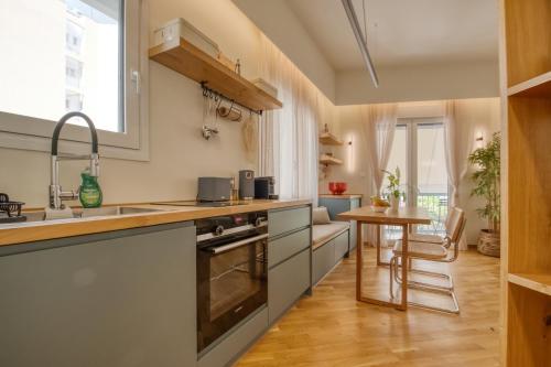 a kitchen with a sink and a table in it at Koukaki Cityscape in Athens