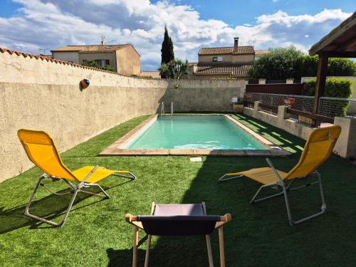 une cour avec deux chaises et une piscine dans l'établissement Maison Des myrtes, à Narbonne