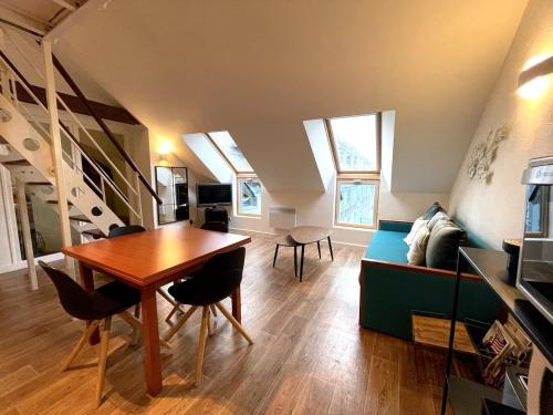 una sala de estar con una mesa y un sofá en Duplex Bord De Mer, en Le Croisic