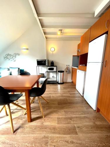 une cuisine et une salle à manger avec une table et des chaises dans l'établissement Duplex Bord De Mer, au Croisic