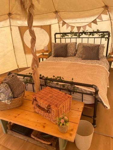 a bedroom with a bed in a tent with a table at Orchard Retreats Glamping At Black Barn Farm Norfolk in Salhouse