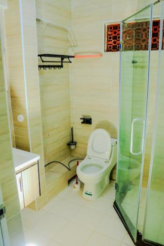 a bathroom with a toilet and a glass shower at Elegant & Stylish Appartments In Nairobi Kileleshwa in Nairobi