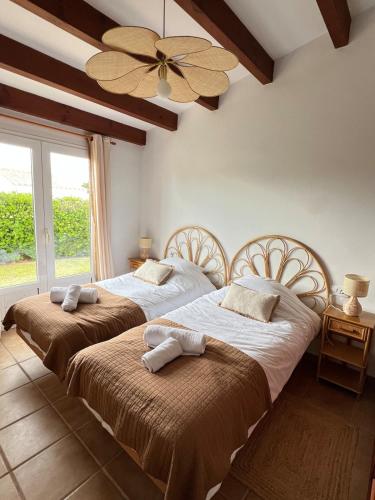 two beds in a bedroom with a ceiling fan at Kasa K - Slowlife in Binibeca in Binibeca