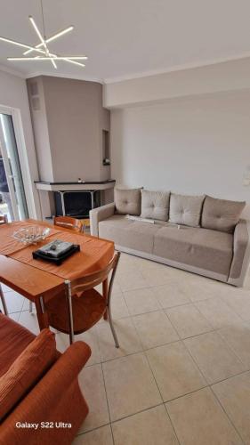 a living room with a table and a couch at Antreas cosy apartment in Paralio Astros