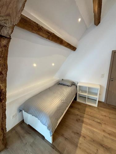 a bedroom with a bed and a wooden floor at Les gîtes de la ferme du moulin in Binche