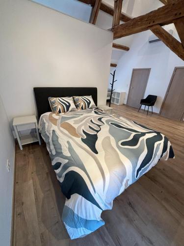 a bedroom with a bed in a room with wooden floors at Les gîtes de la ferme du moulin in Binche