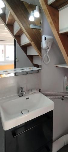 - un évier blanc dans la cuisine avec une fenêtre dans l'établissement P'tite Maison, à Athée-sur-Cher