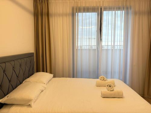 a bedroom with two towels on a bed with a window at H Pipera - 2BR - Lake View in Voluntari