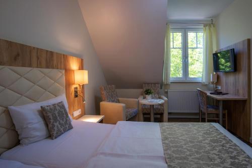 una camera da letto con un letto, una scrivania e una finestra di Restaurant & Hotel Storchenklause a Storkow