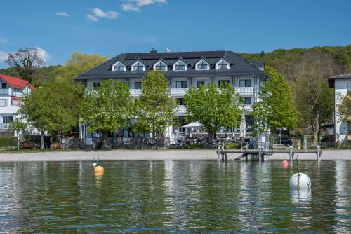 una casa en la orilla de un cuerpo de agua en Ammersee-Hotel en Herrsching am Ammersee