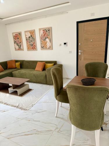 a living room with a green couch and a table at Appartement moderne à l Aouina avec WiFi parking et proche aéroport Tunis Carthage in Ariana