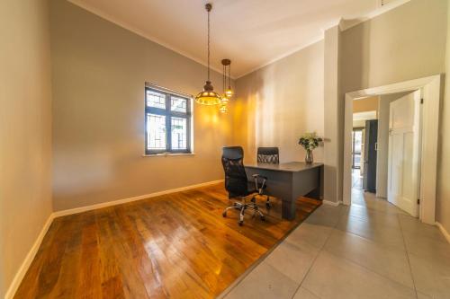 an office with a desk and chairs in a room at Room 6 - LEO Sky Guest House in Simondium