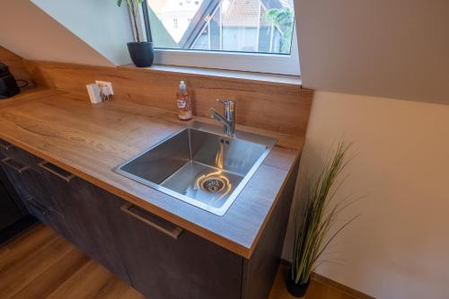 Una encimera de cocina con un fregadero y una ventana. en Mihalca Studio Apartments, en Günzburg