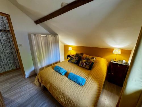a bedroom with a bed with two blue pillows at Domaine de la Maroutière in Saint-Fort