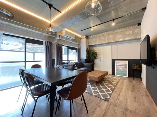 a living room with a table and chairs and a couch at Eims stay Oomori206 in Tokyo
