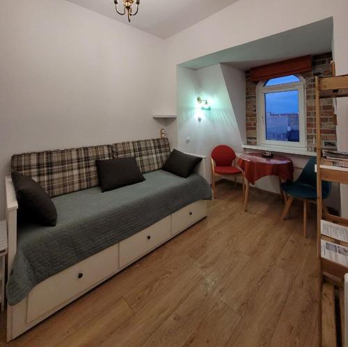 a bedroom with a bed and a table and a window at Stare Gniezno Centrum Miasta in Gniezno