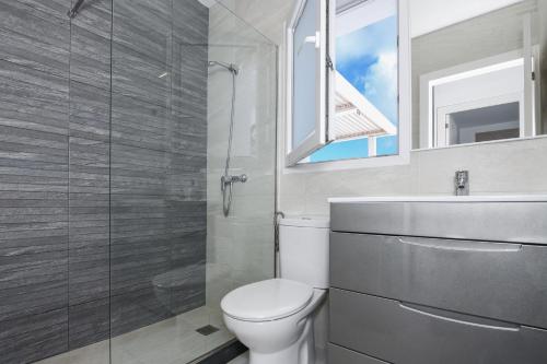 Un baño con inodoro, lavabo y espejo. en Villa Izarenar, en Cala Blanca