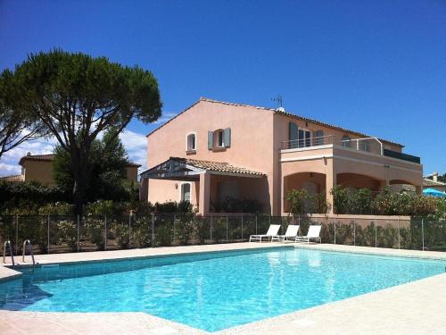une maison avec une piscine devant une maison dans l'établissement la vie en rose, à Grimaud