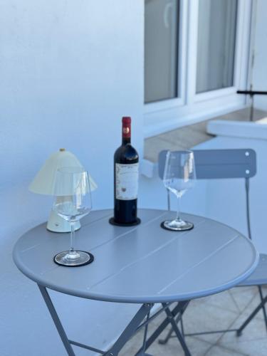 a bottle of wine sitting on a table with two glasses at Westerntor City Apartment in Paderborn