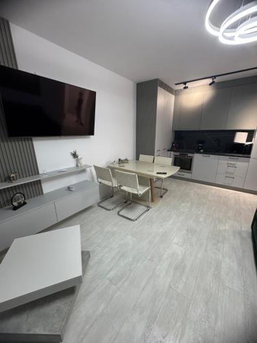 ラダウツィにあるEuro Apartments Radautiの広いリビングルーム(テーブル、テレビ付)