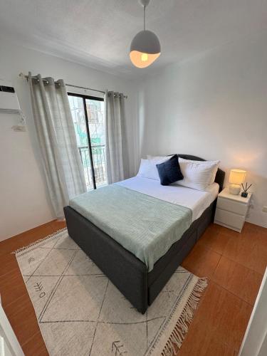 a bedroom with a large bed and a window at Modern Minimalist Luxe Retreat 2 Bedroom with parking in Manila