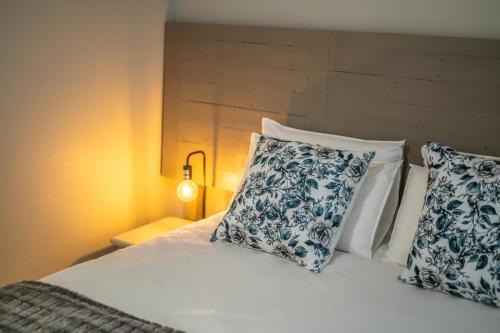 a bed with two blue and white pillows on it at Room 6 - LEO Sky Guest House in Simondium
