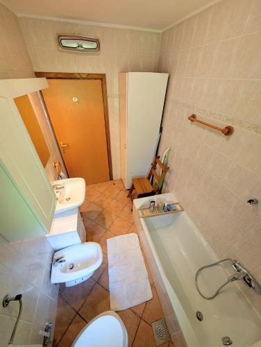 a bathroom with a toilet and a sink and a tub at Apartment Senik in Grgar