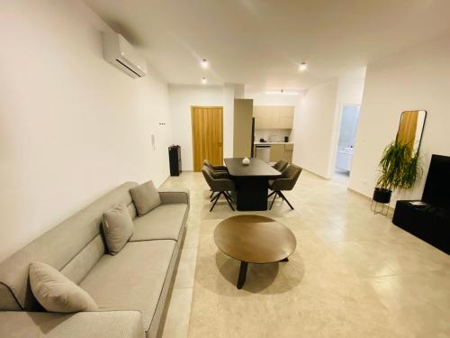 a living room with a couch and a table at Sea view Penthouse Universal Residences in Nea Paphos
