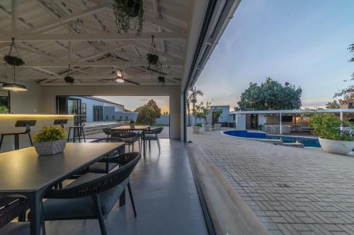 a patio with tables and chairs and a pool at Room 6 - LEO Sky Guest House in Simondium