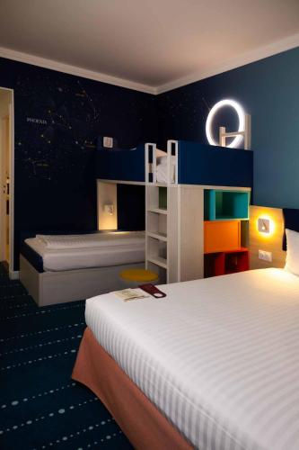 une chambre avec deux lits et un mur bleu dans l'établissement Grand Magic Hotel Marne La Vallée, à Magny-le-Hongre