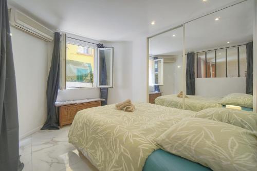 une chambre avec deux lits jumeaux et une fenêtre dans l'établissement Le Jo - Centre - Terrasse - Verrière Côte d'Azur, à Cannes