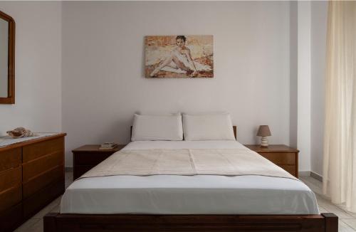 a bedroom with a bed and a painting on the wall at Villa Tsitreli in Sikia