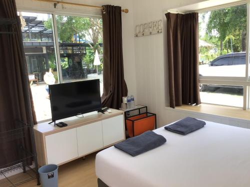 a room with two beds and a flat screen tv at Phalagoon Resort in Ban Chang