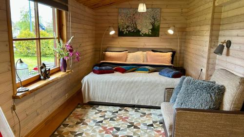 a bedroom with a bed in a room with a window at Goldingen Stone Retreat - Hot Tub and Nature in Kuldīga