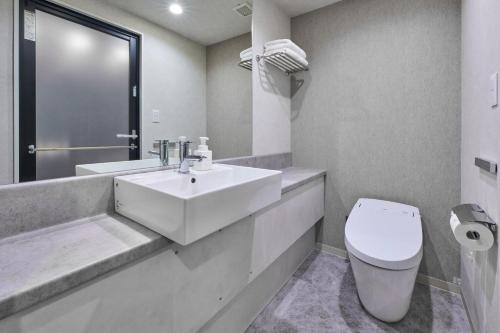 a white bathroom with a sink and a toilet at Hotel Villa Fontaine Grand Tokyo-Shiodome in Tokyo