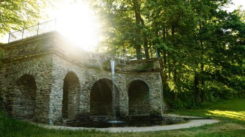 a stone building with the sun shining through the trees at Cha-lu-pa in Šumperk