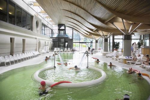un groupe de personnes dans une piscine dans un bâtiment dans l'établissement Cosy Apt Clim 3 étoiles prox lac, rivière Aix Chambéry, à Viviers-du-Lac