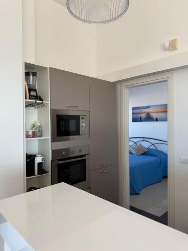 Una habitación blanca con una cama y una cocina. en Rooftop Egadi View, en Marsala