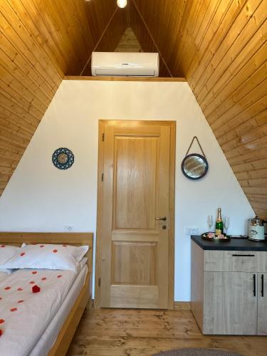 a bedroom with a bed and a wooden door at A FRAME 1 TRANSALPINA in Petreşti