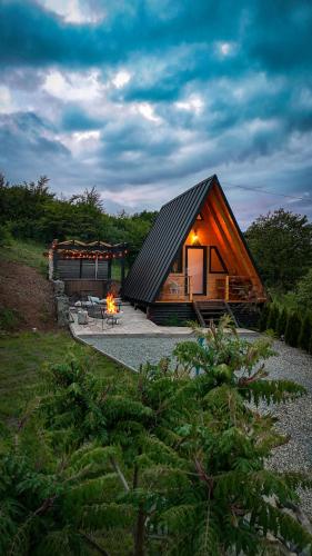a small cabin with a fire in front of it at A FRAME 1 TRANSALPINA in Petreşti