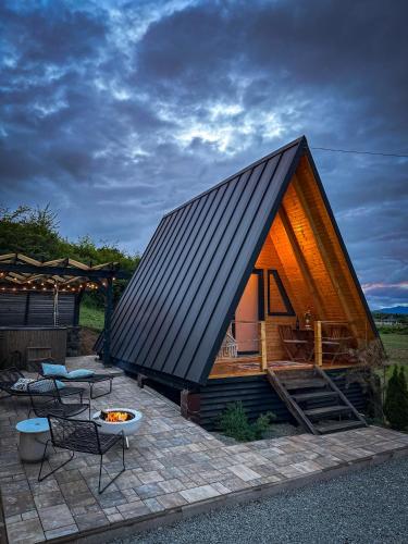 a small house with a black roof on a patio at A FRAME 1 TRANSALPINA in Petreşti