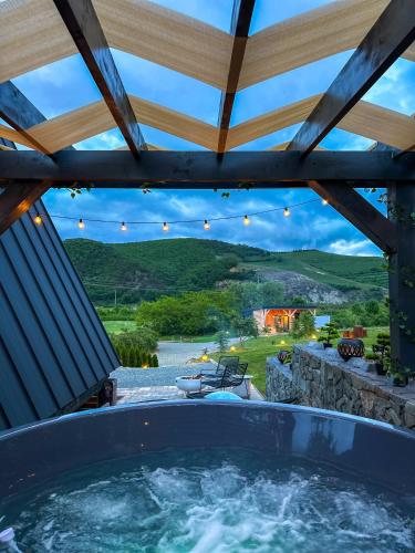 a hot tub in a patio with a roof at A FRAME 1 TRANSALPINA in Petreşti