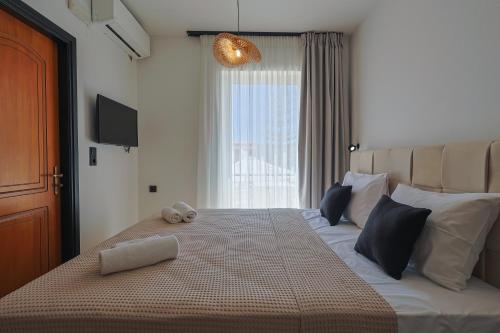 a bedroom with a large bed with a large window at AVENA Suites in Kato Gouves